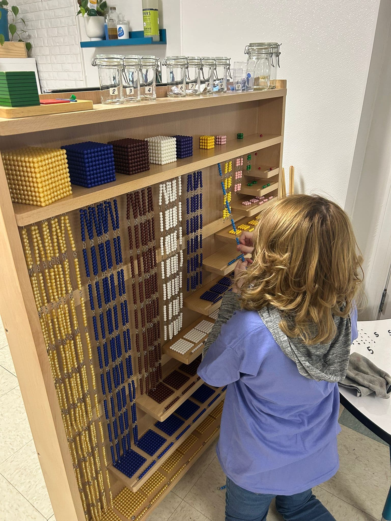 Child working with Montessori bead cabinet materials